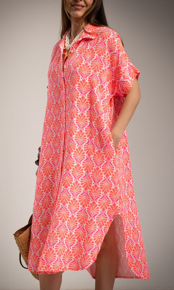 Woman wearing a pink patterned dress against a gray background