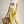 Load image into Gallery viewer, Woman wearing a white t-shirt with a graphic design, yellow pants, and a brown hat, holding a straw bag on a plain background.
