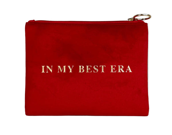 Red pouch with 'IN MY BEST ERA' text on a light wooden surface and gray background