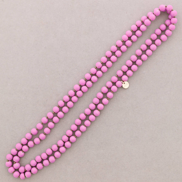 Pink beaded necklace on a light gray background