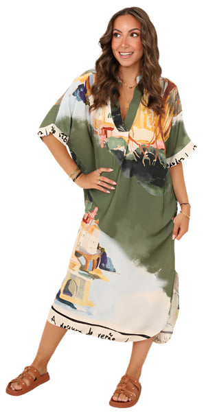 Woman wearing a green dress with colorful print, standing against a white background