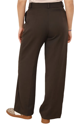 Brown wide-leg pants worn by a person against a white wall.
