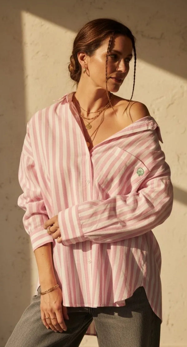 Woman wearing a pink and white striped shirt against a light background