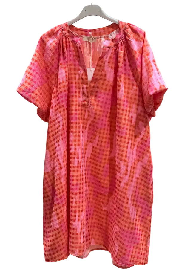 Orange and pink patterned dress on a hanger against a white background