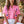 Load image into Gallery viewer, Woman wearing a pink embroidered top sitting outdoors with plants in the background
