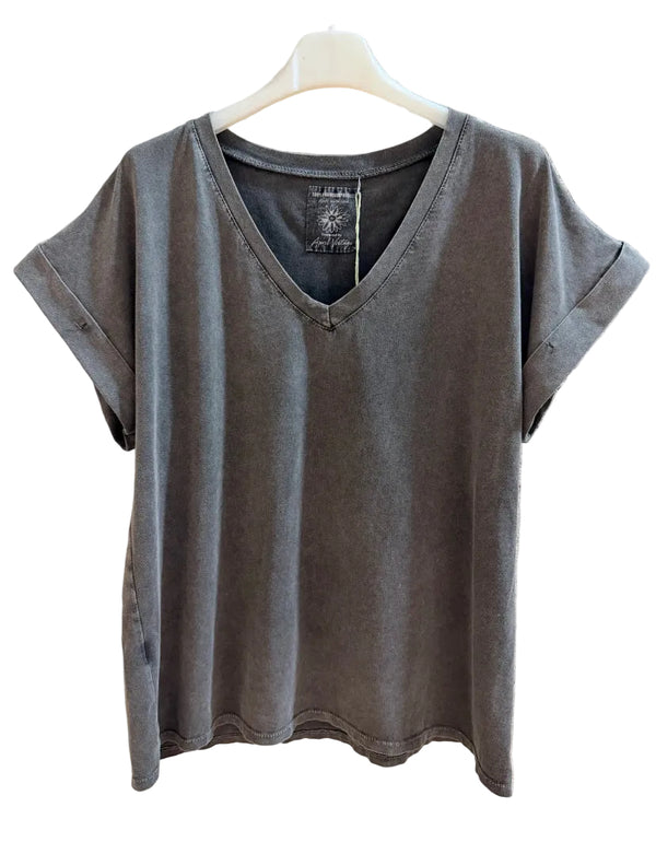 A gray short-sleeve V-neck t-shirt hanging on a white plastic hanger against a textured concrete wall.