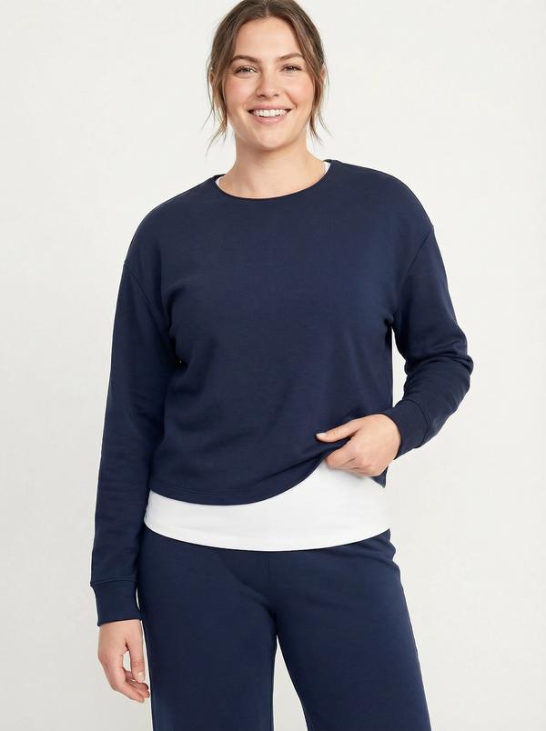 Woman wearing a navy blue sweatshirt and pants on a light gray background