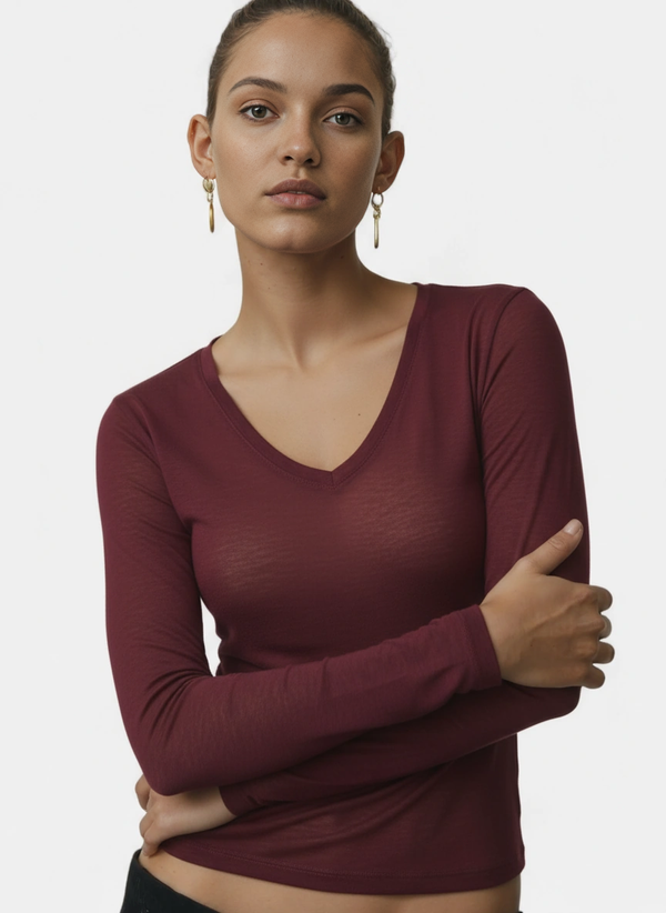 Woman wearing a burgundy cashmere long-sleeve top against a plain background
