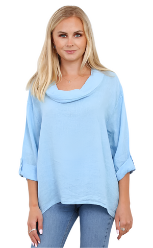 Woman wearing a light blue linen top with a cowl neck