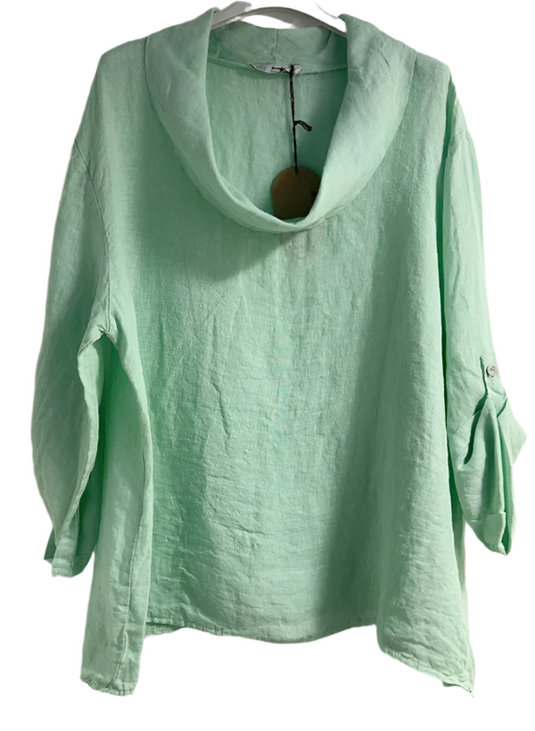 Woman wearing a light green linen top with a cowl neck