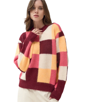 Woman wearing a colorful checkered sweater on a light background