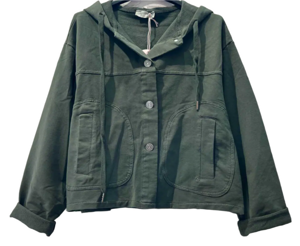 Green jacket with buttons on a hanger against a gray brick wall.