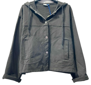 Chocolate jacket with a hood on a hanger against a light gray brick wall.