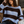 Load image into Gallery viewer, A woman seated in a cafe wearing a chunky knit sweater with wide horizontal stripes in light blue and dark brown. She is wearing dark wash jeans and a brown belt, with a cafe menu and table visible in the background. Close-up of the wide boat neck and chunky ribbed finish on a soft, striped pullover sweater
