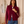 Load image into Gallery viewer, Front view of a woman wearing a women's burgundy fine-knit mock-neck zip-up cardigan with white contrast racing stripes down the sleeves, styled with blue high-waisted jeans.
