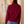 Load image into Gallery viewer, Back view of a woman wearing a women's burgundy fine-knit mock-neck zip-up cardigan with white contrast racing stripes down the sleeves, styled with blue high-waisted jeans.
