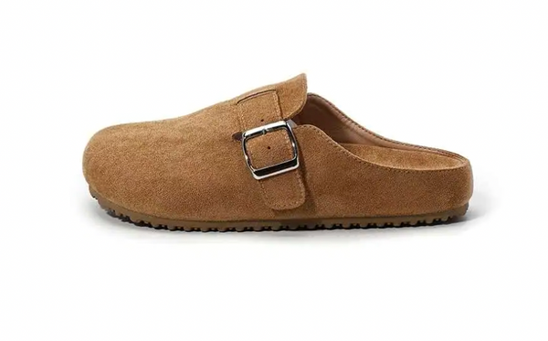 A single tan suede clog-style mule shoe with a silver buckle strap, shown from a side profile on a white background.
