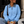 Load image into Gallery viewer, Front view of a woman seated outside a cafe wearing a powder blue fine-knit zip-up cardigan that features a contrast medium-wash denim collar and cuffs, paired with light blue jeans
