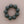 Load image into Gallery viewer, A beaded bracelet made of matte dark green round beads, arranged in a circle on a neutral beige background.
