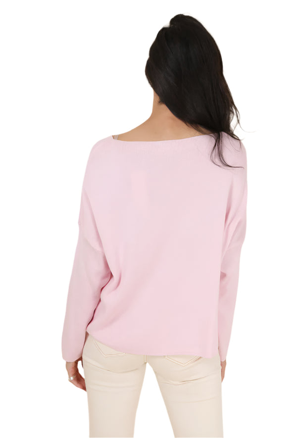 Person wearing a light pink sweater against a beige background