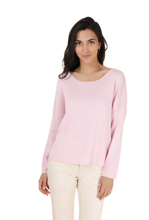 Woman wearing a light pink long-sleeve top against a beige background