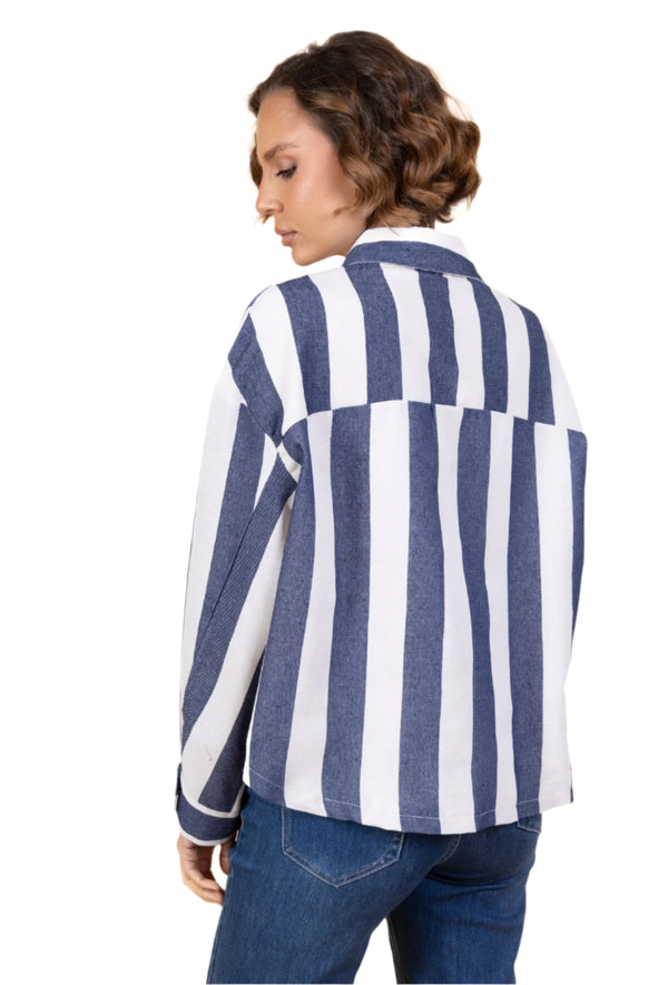 Woman wearing a blue and white striped shirt against a beige background